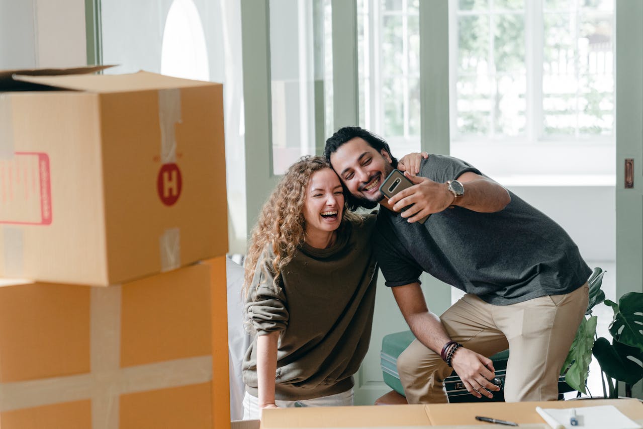 A happy couple packing boxes and taking a selfie